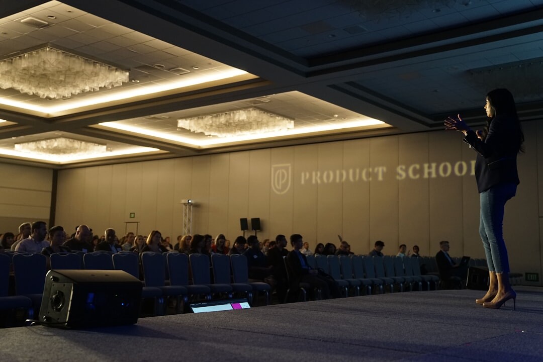 Speaker presenting on a large conference stage